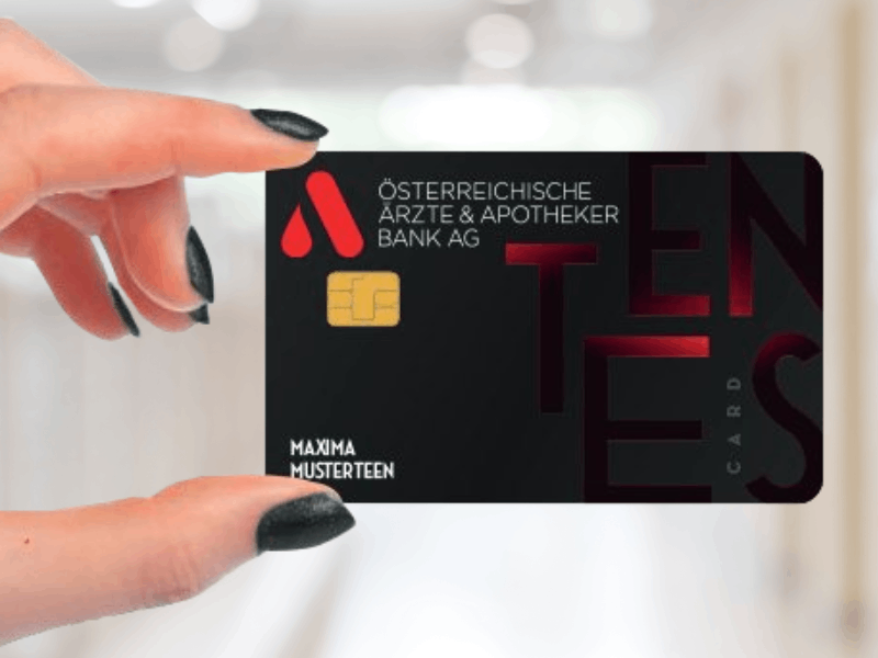 Hand mit schwarz lackierten Fingernägeln, die Teenscard hält